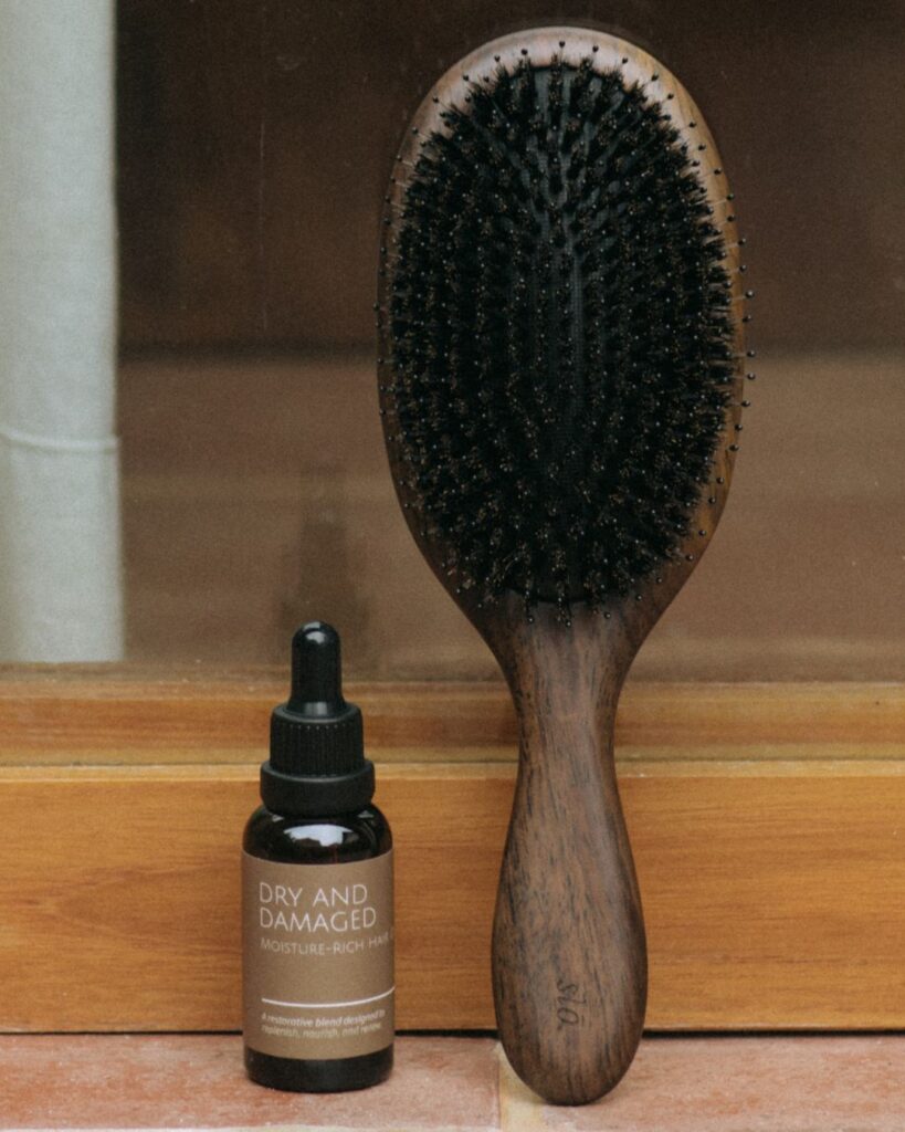 Sandalwood hair brush and plant-based oil treatment for dry, sun-damaged hair in Bali.